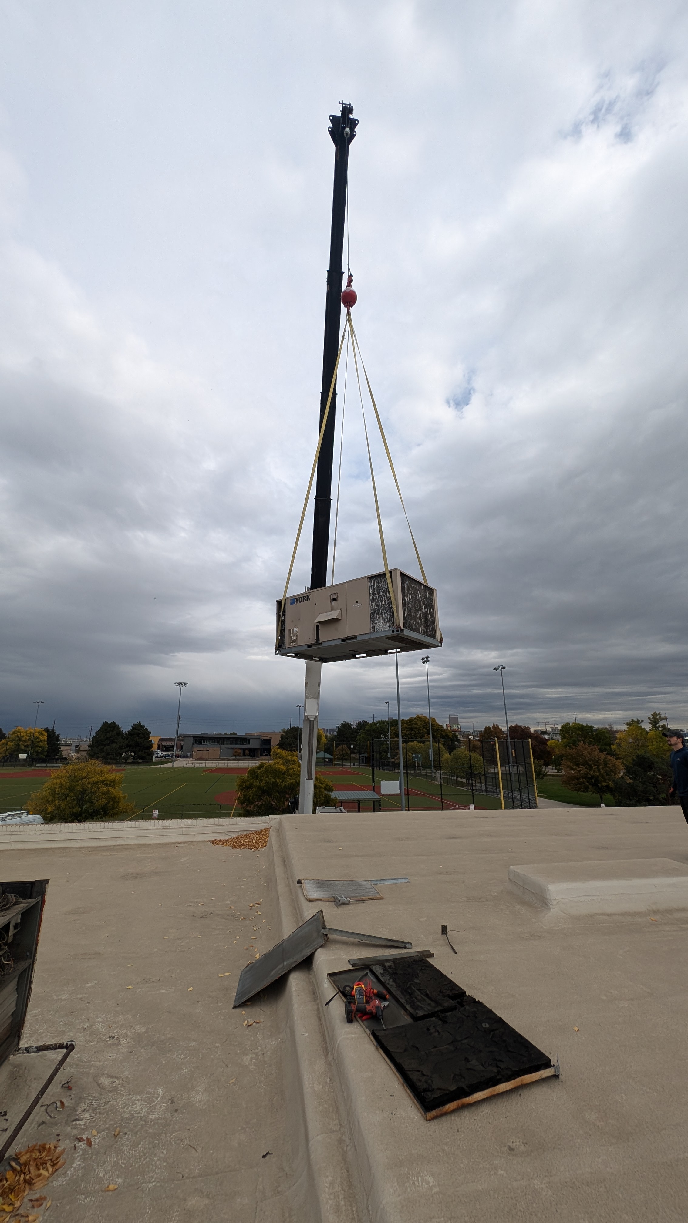 A roof top HVAC unit for heating and cooling on a crane in Edgewater, CO